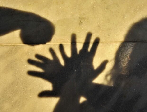 Sombras de mãos levantadas diante de um punho, em imagem ilustrativa sobre violência contra mulheres